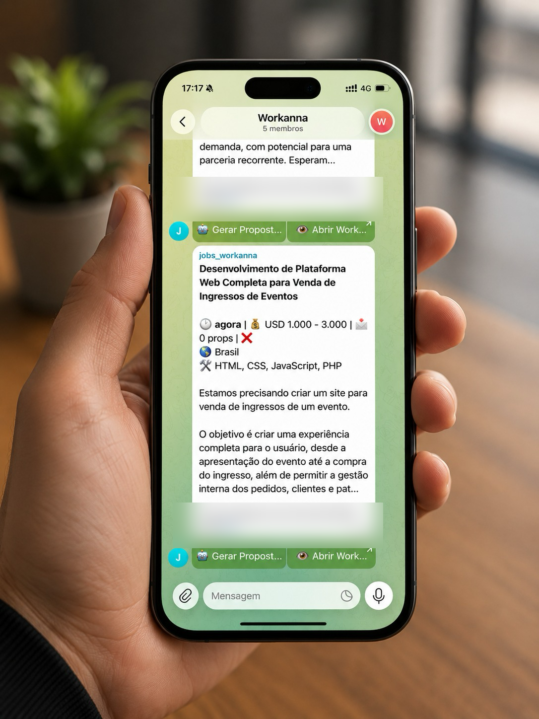 Mão segurando celular com o grupo do Freela+ no Telegram mostrando um projeto do Workana